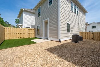 A house with a gravel driveway and a wooden fence.